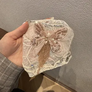 Mascherina decorativa in pizzo con paillettes, strass a farfalla e nappe di cristallo.