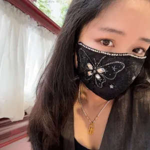Detail view of a black lace rhinestone butterfly face mask, fashionable and breathable.