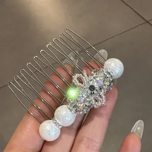 Gros plan détail de peigne à cheveux perle strass nœud, accessoire cheveux scintillant.