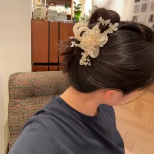 Detailansicht einer koreanischen Kristall Blumen Haarklammer mit Perlen und feinen Organza Blüten.