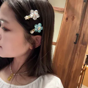 Gros plan détail de la pince à cheveux fleur de cristal avec strass brillants sur les cheveux.