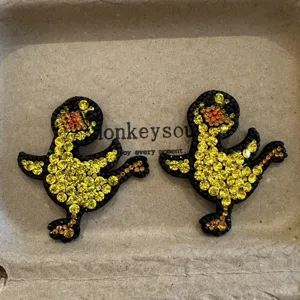 Detailed close-up of cute cartoon duck rhinestone hair clips, sparkling crystal side hair pins.