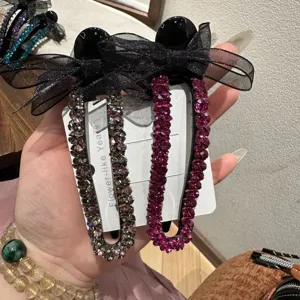 Dettaglio ravvicinato di eleganti fermagli per capelli con strass e fiocchi in rete nera.