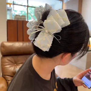 Detailansicht der hellblauen Netz Haarkralle mit bestickter Schleife und Perle.
