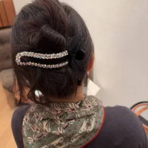 Dettaglio molletta per capelli con strass e fiocco in tulle, fermaglio elegante brillante.
