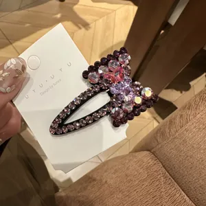 Primer plano detallado del pasador de pelo con lazo de pedrería brillante y cristales finos.