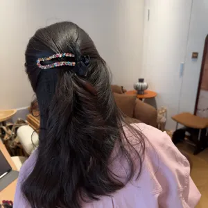 Vista dettagliata della molletta per capelli con fiocco in strass scintillante, accessorio chic.