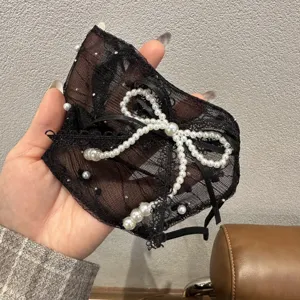 Detailed close-up shot of black lace face veil adorned with chic pearls and bow knot.