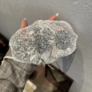 Exquisite rhinestone lace face mask detail, floral embroidery sparkling crystal design.