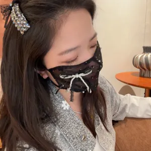 Close-up detail of the stylish black lace pearl mask, showing fine craftsmanship and design.