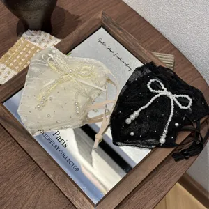 Detailed view of fashionable lace pearl masks with elegant bow decorations and adjustable straps.
