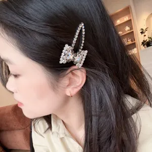 Detalle de pinza para el pelo con lazo de strass, accesorio de cristal elegante.