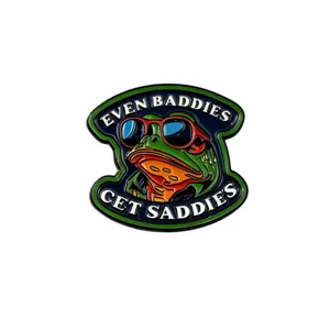 Gros plan détaillé d'une broche en métal émaillé créatif avec un design de grenouille cool.