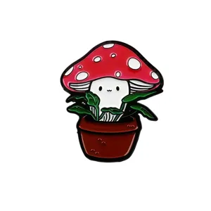 Primo piano di una simpatica spilla smaltata a fungo, colori vivaci con dettaglio di pianta in vaso.