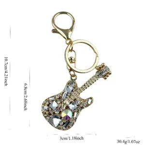Detailed view of the gold-tone metal guitar keychain adorned with sparkling rhinestones.
