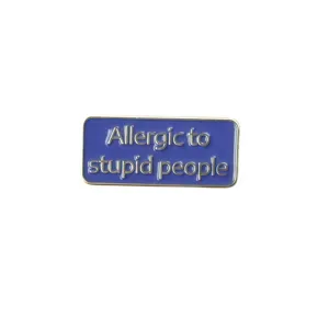 Close-up detail of the funny enamel lapel pin with blue background and silver quote letters.