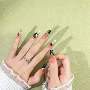 Uñas postizas largas de ataúd con degradado negro, pedrería plateada y diseño de lazo.