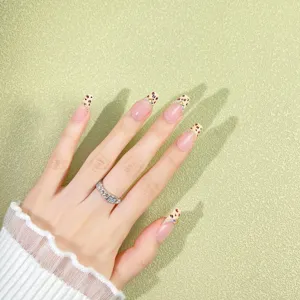 Faux ongles courts en coffret faits main avec bouts français léopard et strass scintillants.