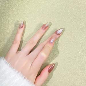 Close up detail view of handmade champagne gold cat eye press on nails with fine glitter design.