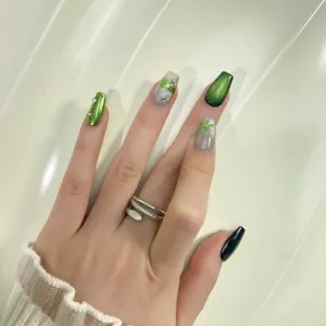 Handmade green cat eye press-on nails with delicate rhinestones and chic botanical art.