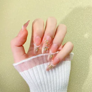 Nude pink gradient press-on nails with sparkling rhinestones, pearls and floral crystal design.