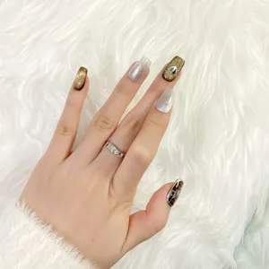 Uñas postizas press-on de ámbar craquelado hechas a mano con detalles de estrellas doradas.