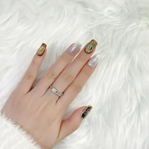 Uñas postizas hechas a mano con diseño de ámbar craquelado y purpurina plateada, estilo lujoso.