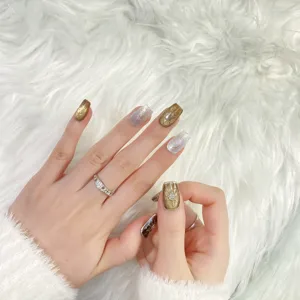 Uñas postizas hechas a mano con efecto craquelado ámbar y detalles de lujo oro y plata.