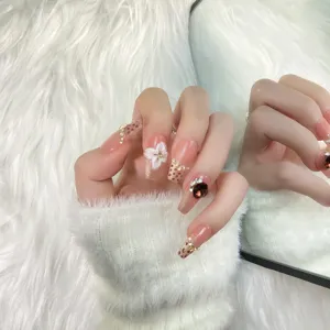 Uñas postizas hechas a mano con base rosa nude, estampado de leopardo y pedrería.