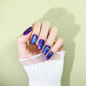 Handmade press-on nails in cool blue-purple cat eye style, oval shape, stylish and shiny variant.