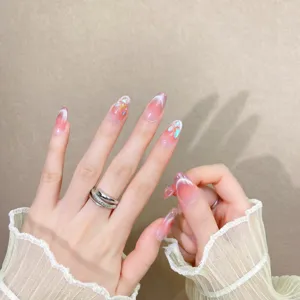 Uñas postizas hechas a mano con degradado rosa transparente y diamantes. Vista detallada.