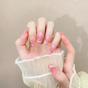 Uñas postizas hechas a mano con degradado rosa blush, efecto ojo de gato y pedrería brillante.