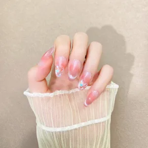Detalle de uñas postizas hechas a mano con degradado de rubor rosa y efecto ojo de gato.