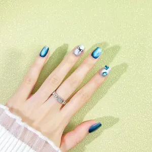Uñas postizas efecto ojo de gato azules con bonito lazo y brillantes para verano.
