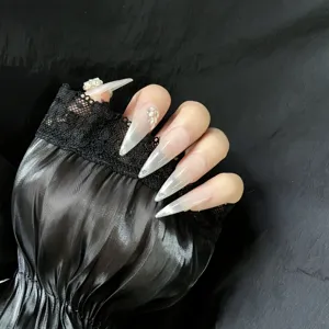 Handmade stiletto press-on nails with nude pink gradient and sparkling rhinestones.
