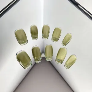 Avocado green cat-eye press-on nails with glitter edges, elegant fake nail detail shot.