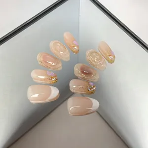 Handmade nude French press-on nails detail with cat eye effect, fine glitter and rhinestones.