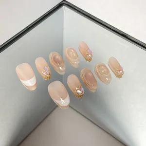 Handmade press on nails detail view featuring nude cat eye french tips glitter and pearl rhinestones