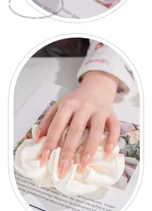 Vista detallada de uñas postizas hechas a mano con líneas doradas elegantes en base nude, chic.