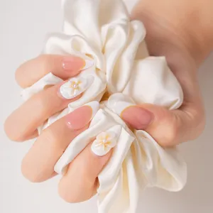 Stunning press-on nails featuring French nude base, 3D floral design, and elegant pearl accents.