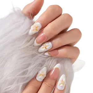 Hand showcasing press-on nails featuring 3D floral designs and elegant French tip style.