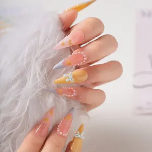 Uñas postizas stiletto largas con degradado rosa amarillo perla lazo manicura dulce