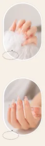 Détail des faux ongles nude faits à la main avec des perles 3D et des fleurs délicates.