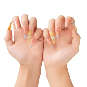 Uñas postizas stiletto largas con degradado rosa-amarillo, perlas y lazos bonitos para estilo dulce.