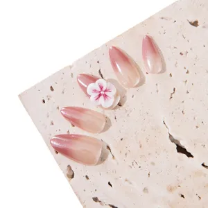Handcrafted press-on nails with elegant pink ombre gradient and 3D white flower design for women.