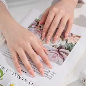 Uñas postizas hechas a mano media larga ataúd nude con elegantes líneas doradas estilo ins.