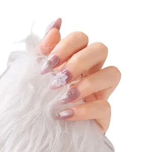 Short press-on nails with cat-eye purple finish, delicate rhinestones and 3D floral accent.
