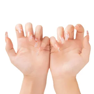 Faux ongles nude faits main avec perles et fleurs 3D blanches pour un style élégant.