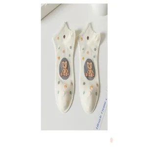 Détail du motif de petit ours mignon sur chaussettes courtes en coton blanc doux.