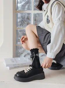 Close-up detail of Japanese Lolita black mid-calf socks featuring cute white lace and ribbon bow.